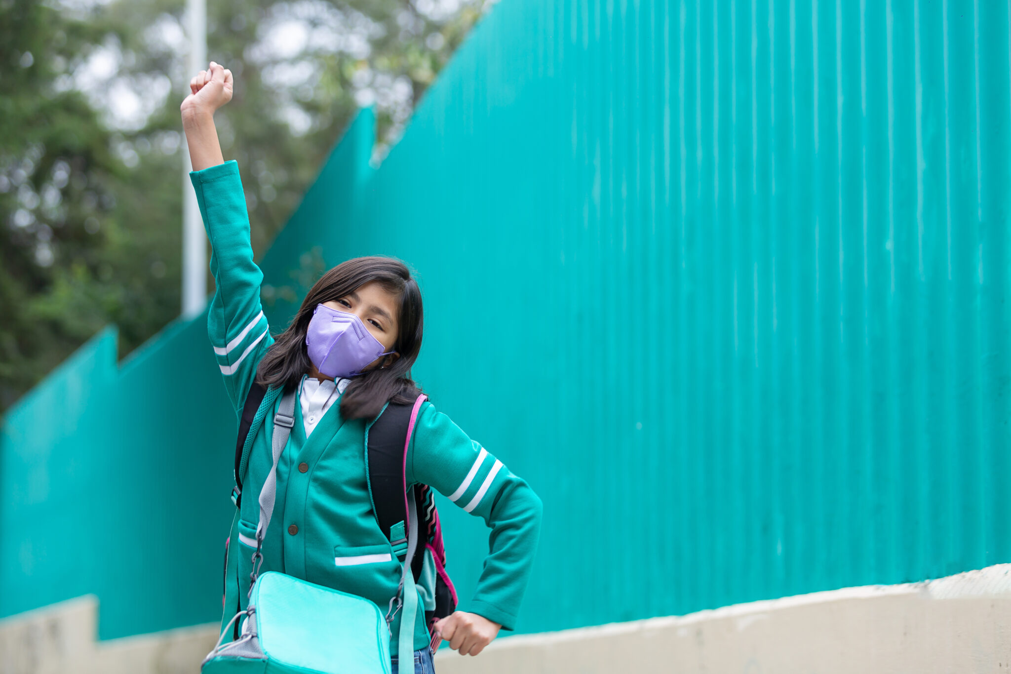 Menina mexicana super feliz animada de volta à escola usando máscara protetora após bloqueio de coronavírus