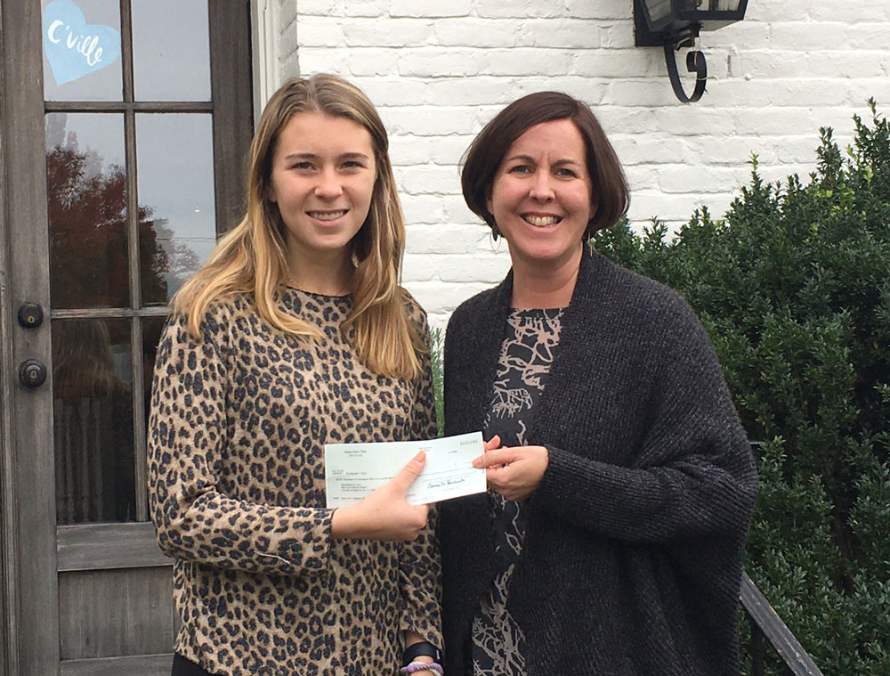 Cecilia Hall of Kappa Alpha Theta gives PCASA President Kate Duvall a check for the funds they raised at their annual Waffle CASA. 10.4.21